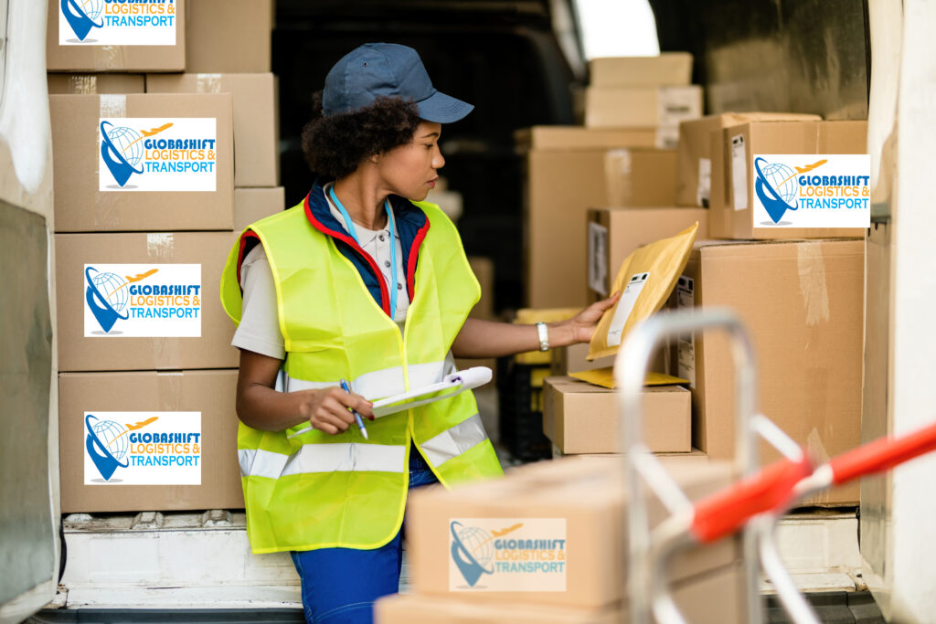 female african american deliverer sorting packages in a van.